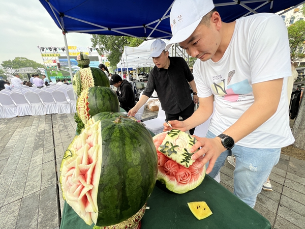 圖為在南藝后街，一藝術家正在用東臺西瓜進行藝術雕刻。曈暚 攝